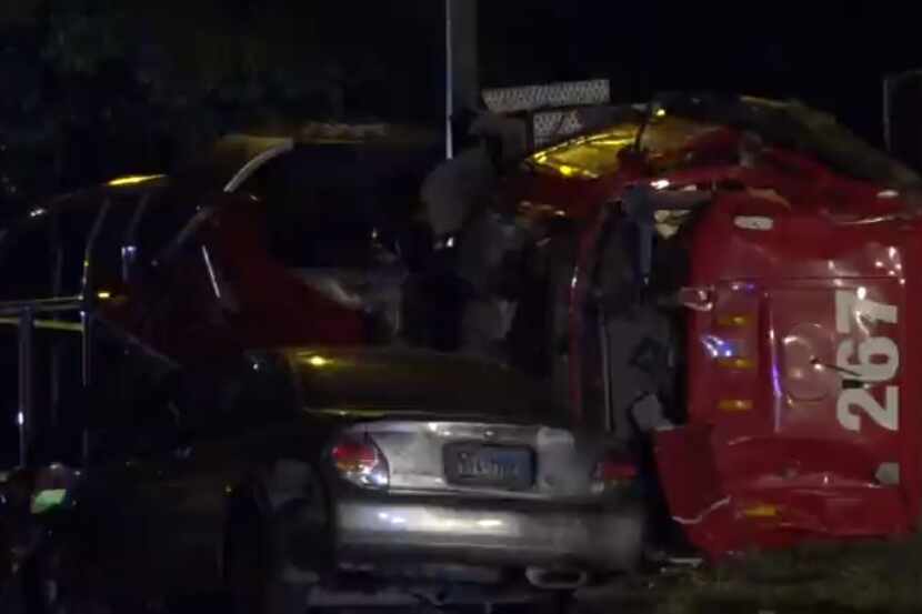 An overturned 18-wheeler lies against a car that crashed into it Tuesday night in...