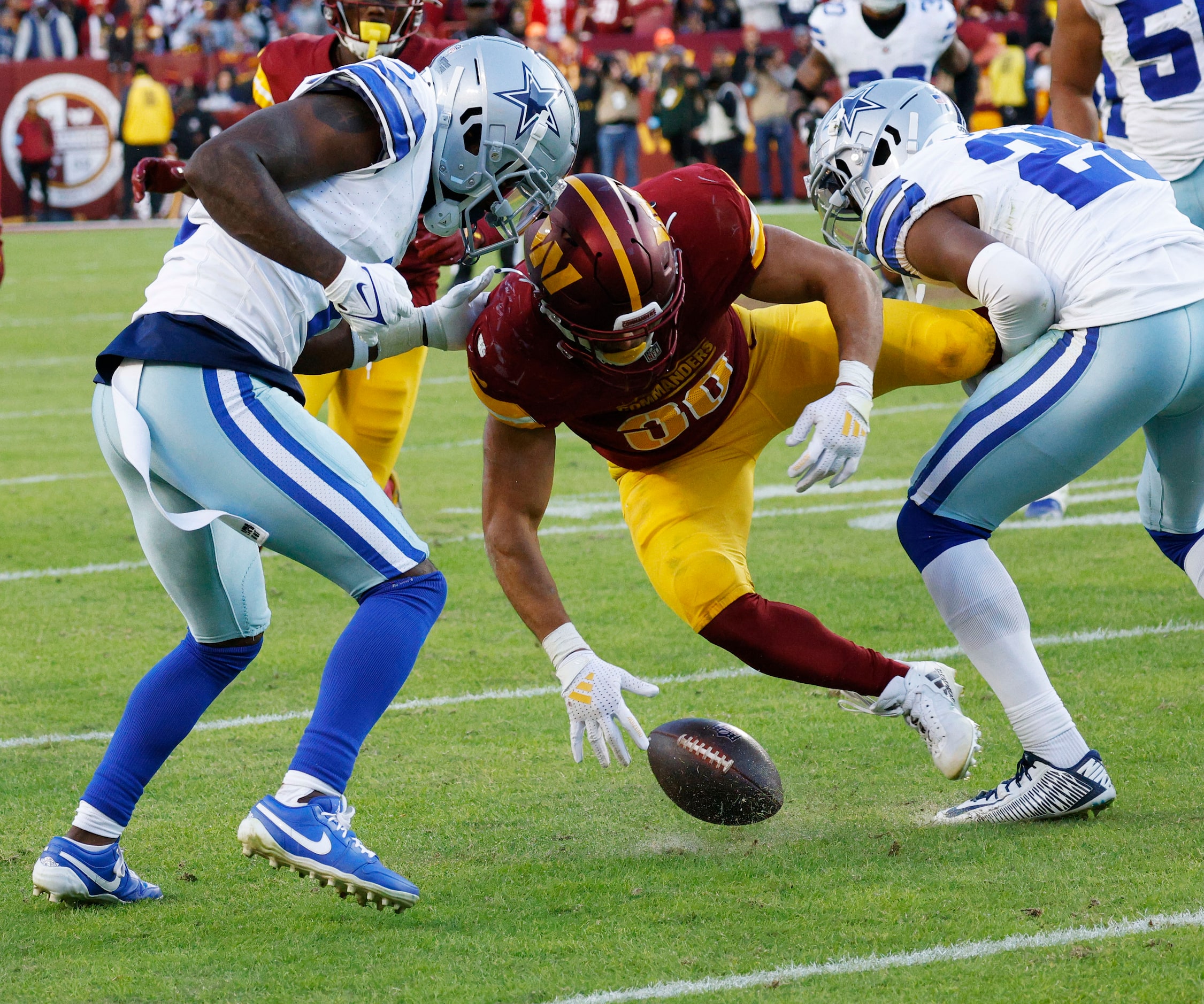 Washington Commanders running back Austin Ekeler (30) loses the ball after being tackled by...