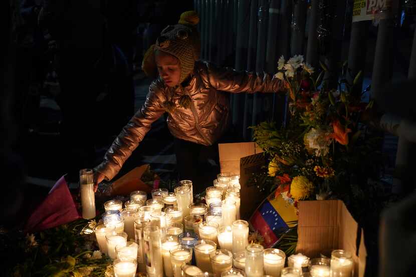A Venezuelan migrant girl lights a candle during a vigil for the victims of a fire at an...