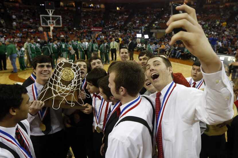 Ponder's Josh Peterson, right, takes a selfie portrait of himself, teammates and the trophy...