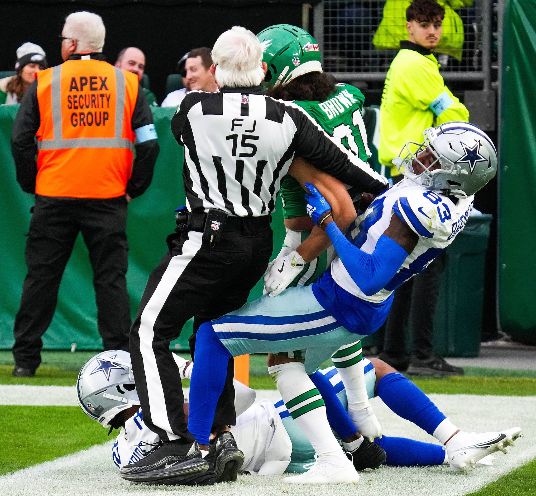 Field judge Rick Patterson (15) tries to separate Philadelphia Eagles safety Sydney Brown...