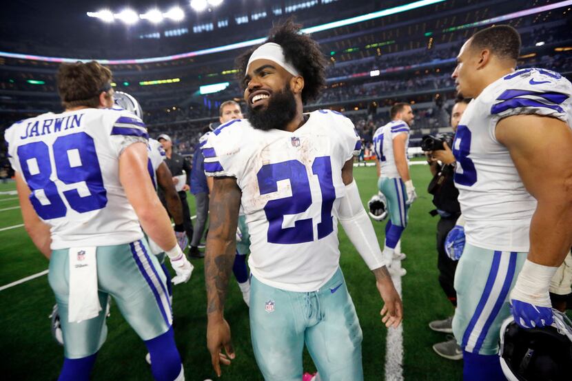 Dallas Cowboys running back Ezekiel Elliott (21) smiles big as he congratulates teammates on...