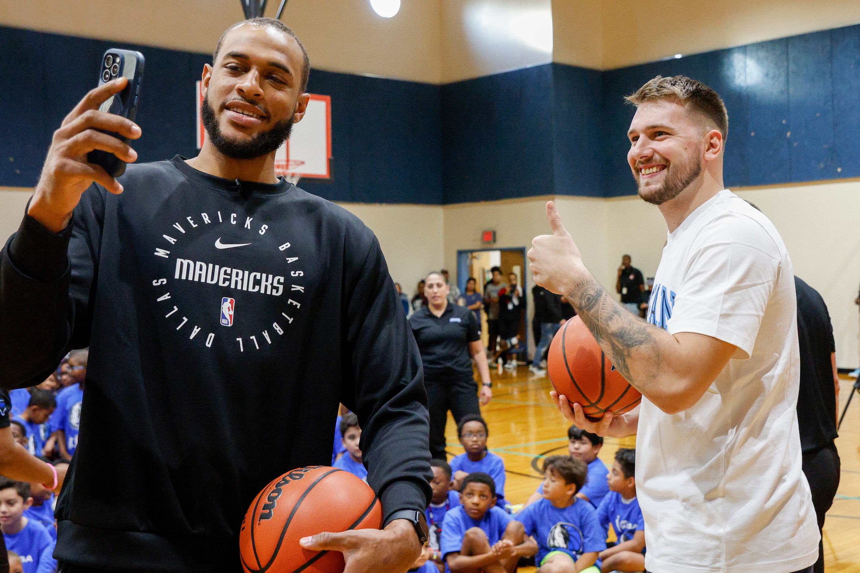 Dallas Mavericks center Daniel Gafford takes a selfie with guard Luka Doncic during a...