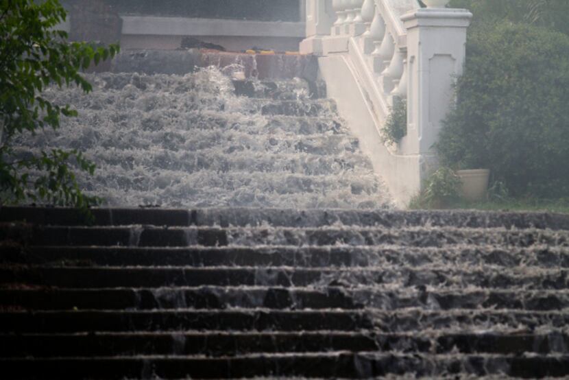 Water rushed down the staircase as Dallas Fire-Rescue crews fought a blaze at the former...