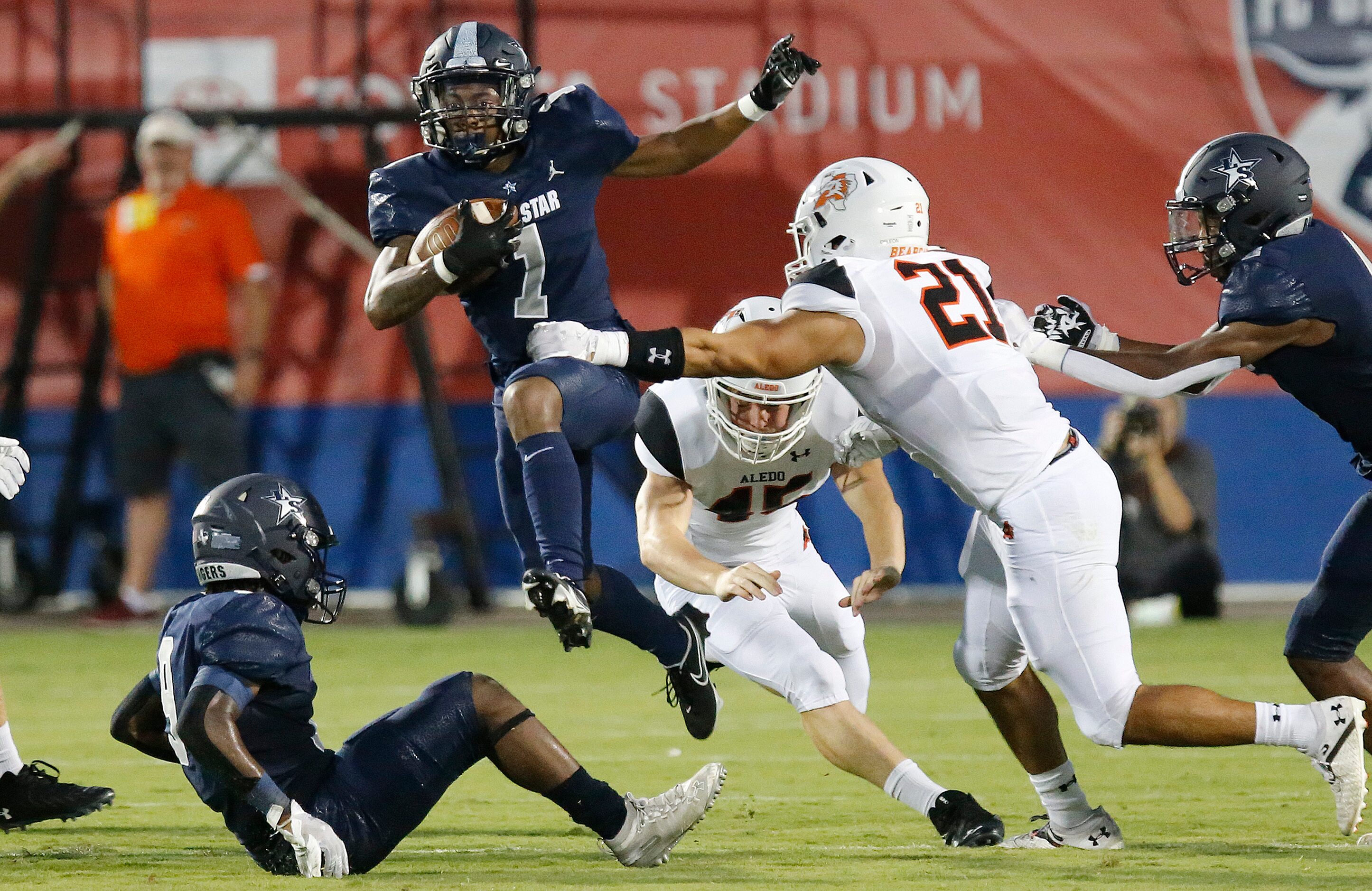 Lone Star High School wide receiver Gerald Harris (1) hurdles his own blocker on a kick...