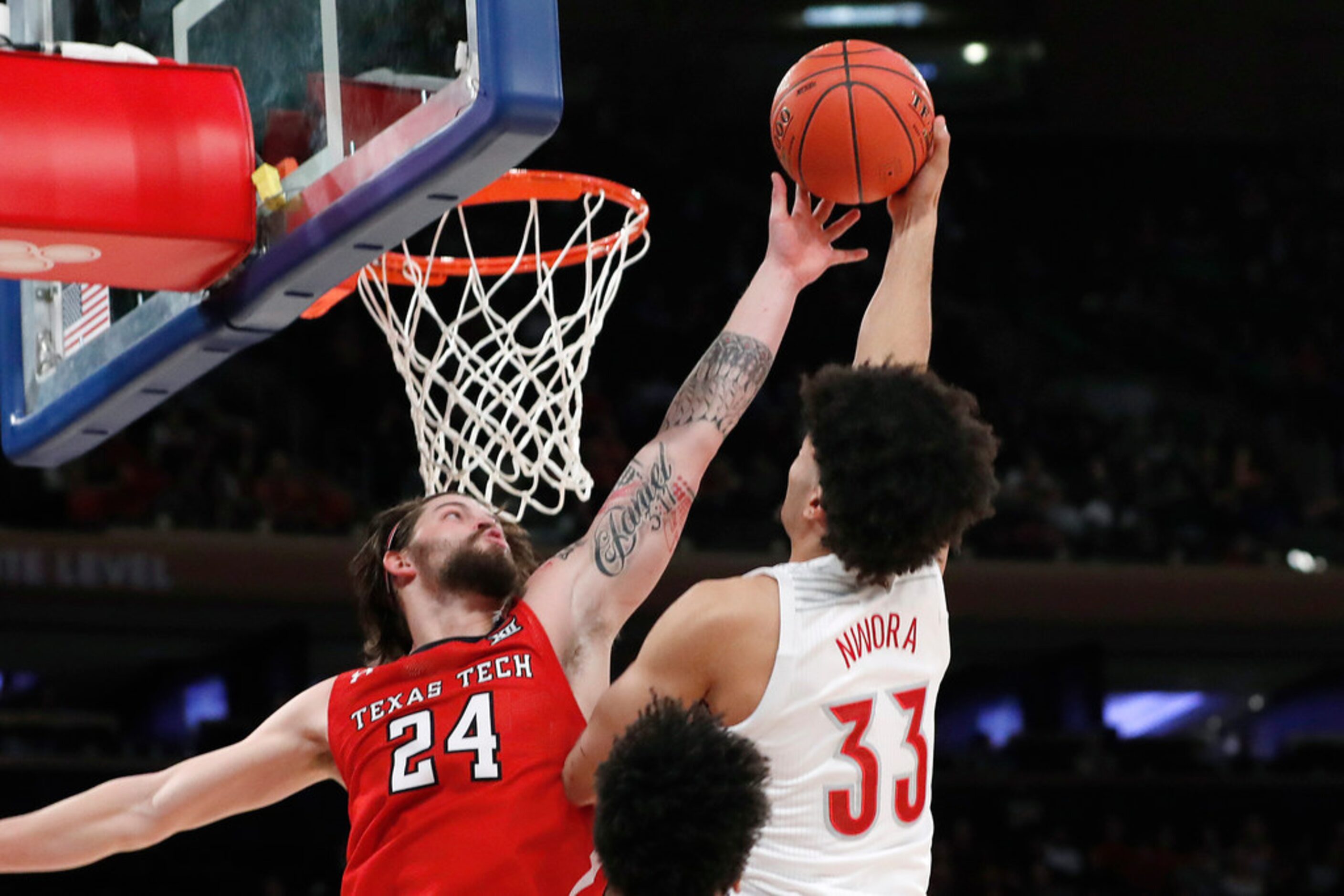 Texas Tech guard Avery Benson (24) defends against a shot by Louisville forward Jordan Nwora...