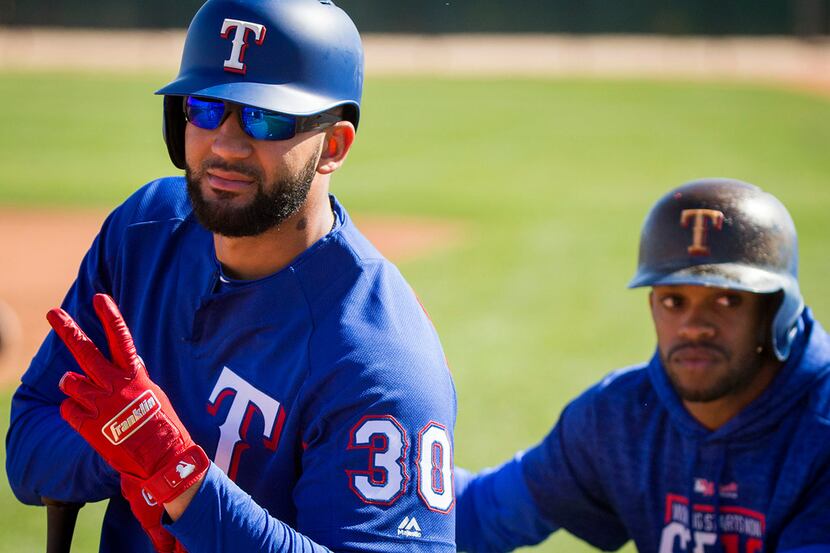 Texas Rangers outfielder Nomar Mazara waits his turn in the batting cage with Delino...