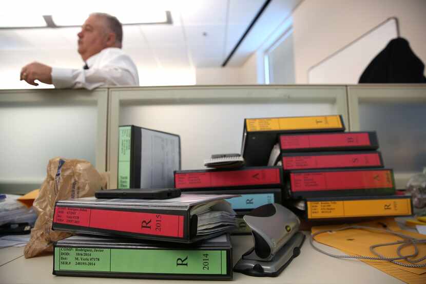 Cold case files are stacked on the desk of Det. Michael Yeric at Dallas Police Department...
