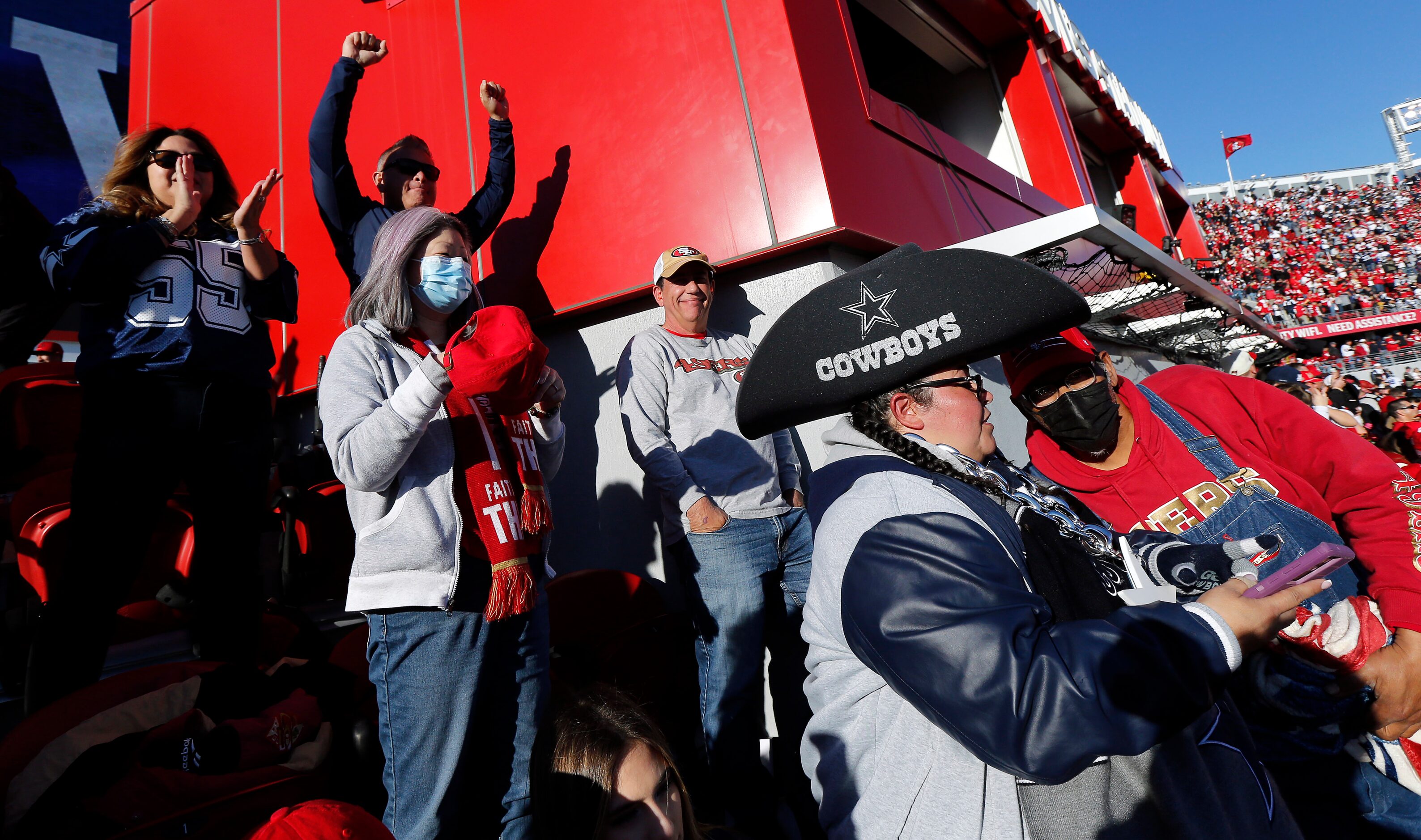 Surrounded by San Francisco 49ers fans in the upper deck, Dallas Cowboys fans cheer their...