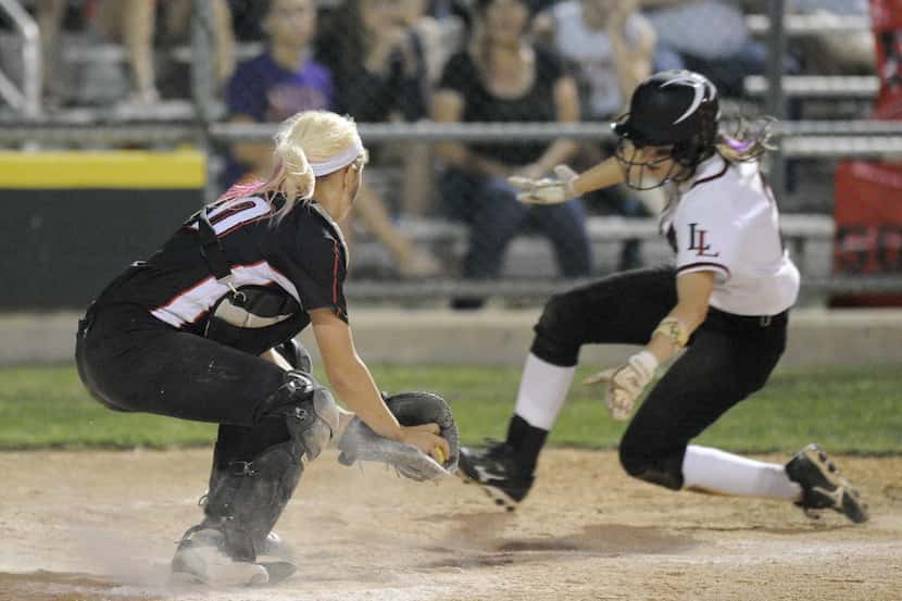 Lovejoy's Autumn Keefer slides around Legacy catcher Reagan Wright to score a run during a...