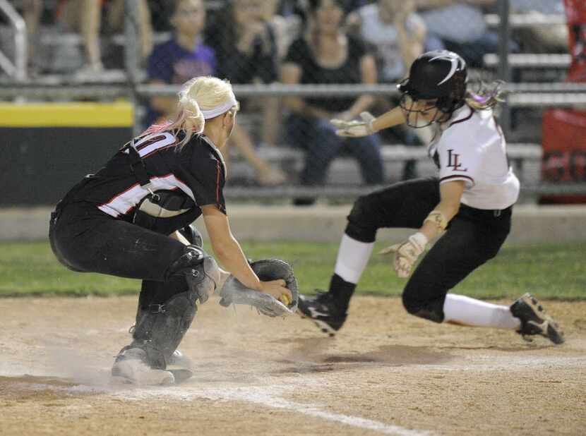 Lovejoy's Autumn Keefer slides around Legacy catcher Reagan Wright to score a run during a...
