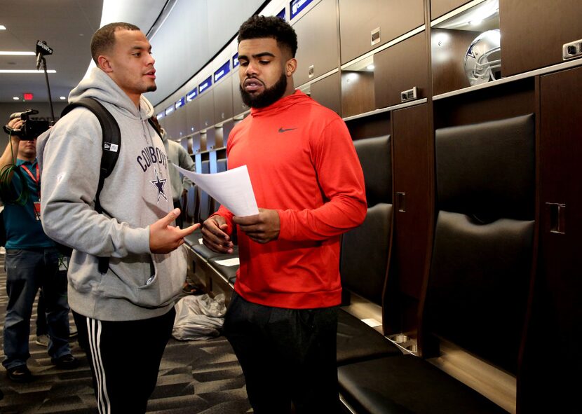 Dallas Cowboys quarterback Dak Prescott talks to running back Ezekiel Elliott during locker...