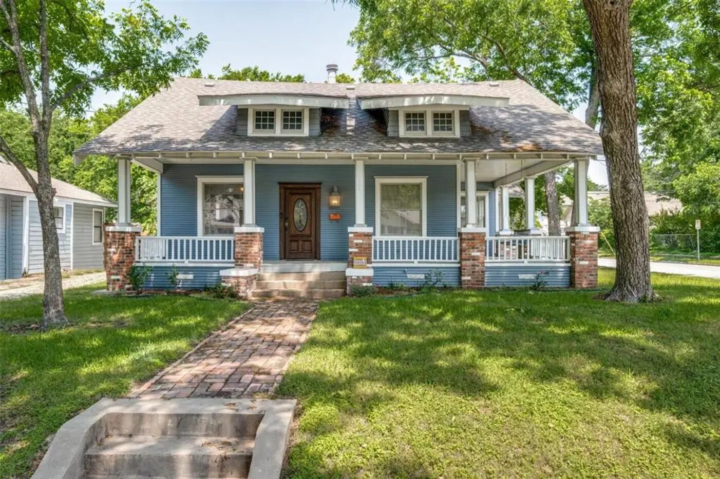 Exterior of a craftsman home painted blue and white with a large porch