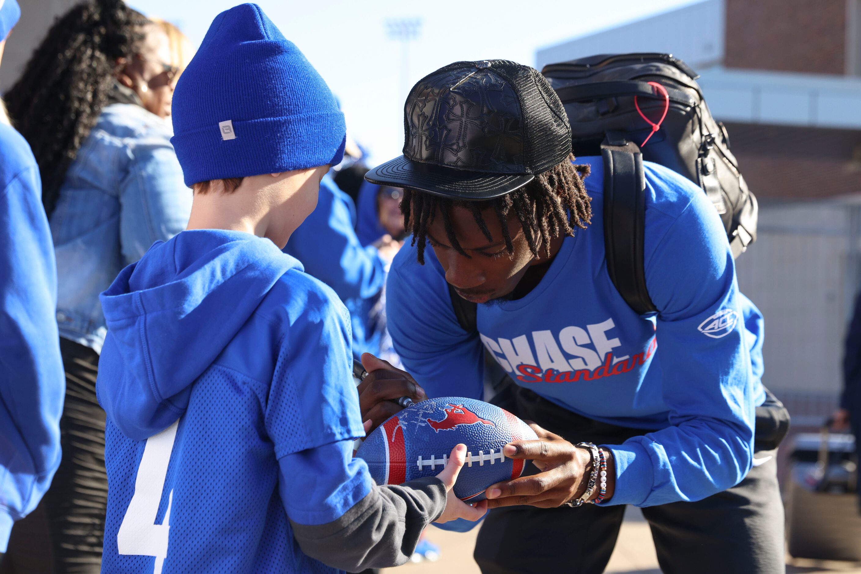 Will Mayon, 8, receives an autograph from SMU QB Kevin Jennings during a send-off party the...