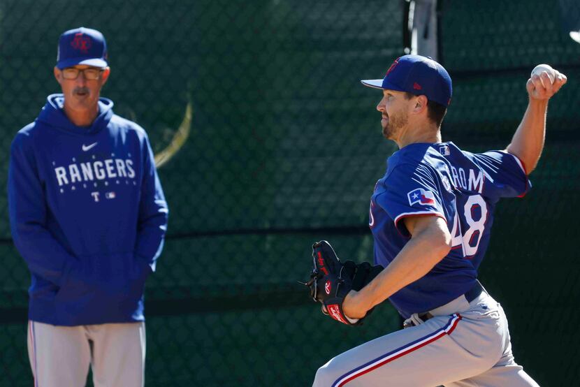 Texas Rangers pitching coach Mike Maddux, left, watches as pitcher Jacob deGrom throws a...
