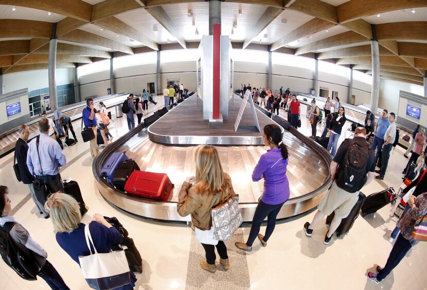 Airline passengers wait for their luggage in the Dallas Love Field baggage claim area in...