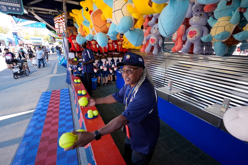 Artis Frank calls out to guests as they walk past a game attraction on the Super Midway at...