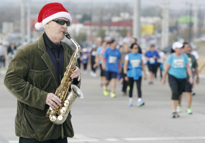 Saxophonist 'Slimey Lemon' plays as runners make their way across the Margaret Hunt Hill...
