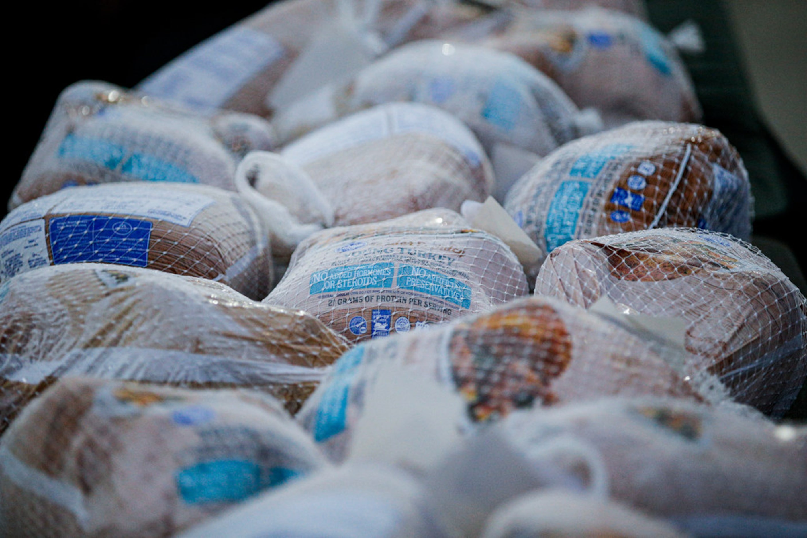 Frozen turkeys wait to be handed out to families in need by the Texas Rangers Baseball...