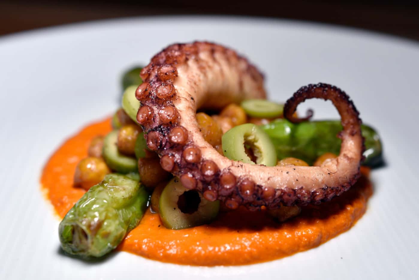 Octopus with chick peas, olives and shishito peppers on romesco sauce, an antipasto at...