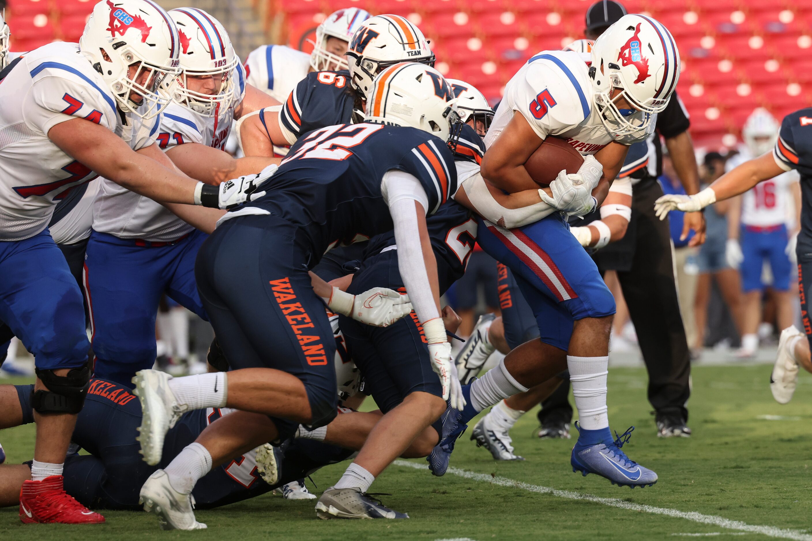 Grapevine High School’s  Victor Deal Cruz (5) pushes through the line of scrimmage to run...