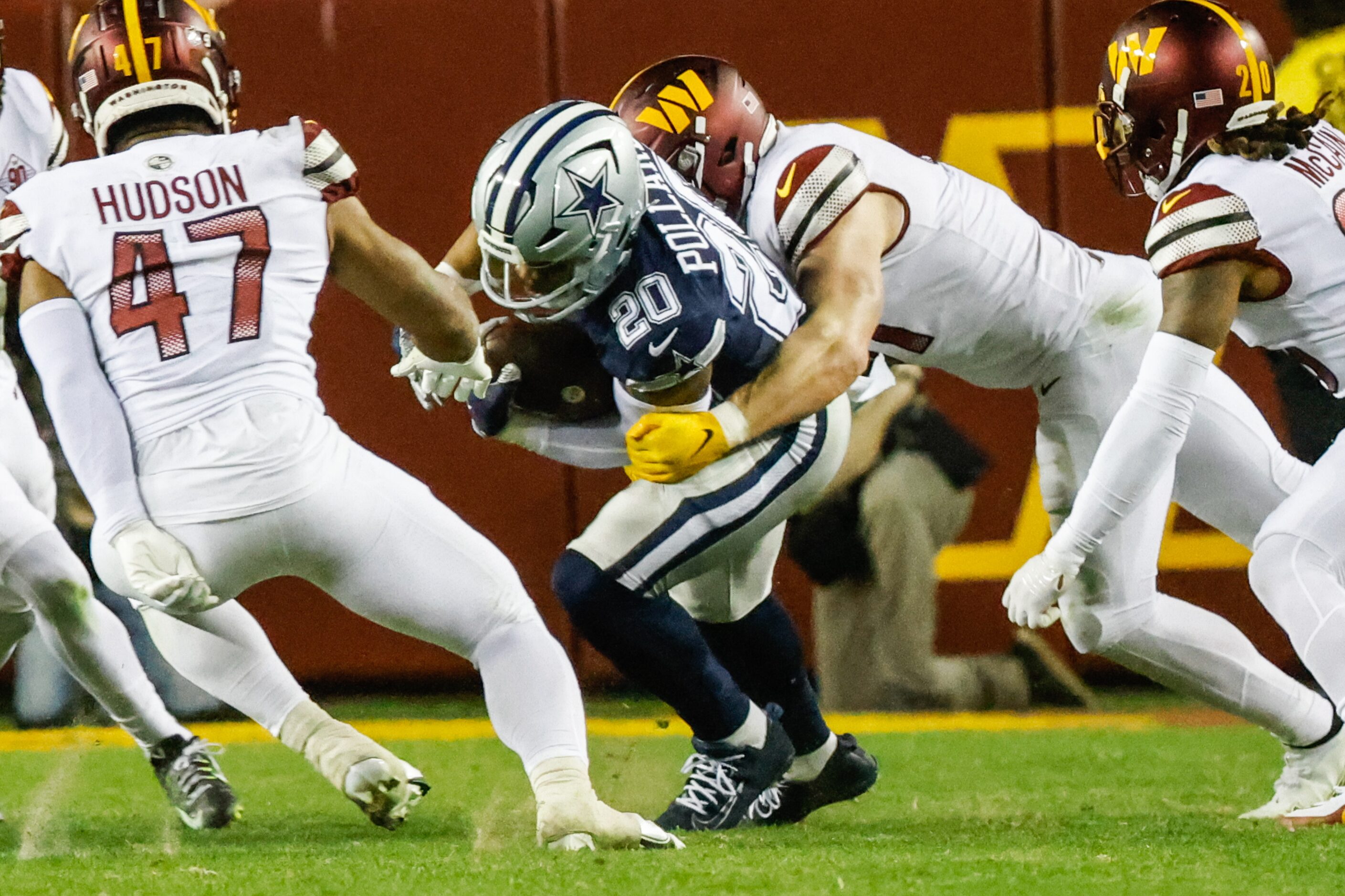 Dallas Cowboys running back Tony Pollard (20) gets tackled by Washington Commanders...