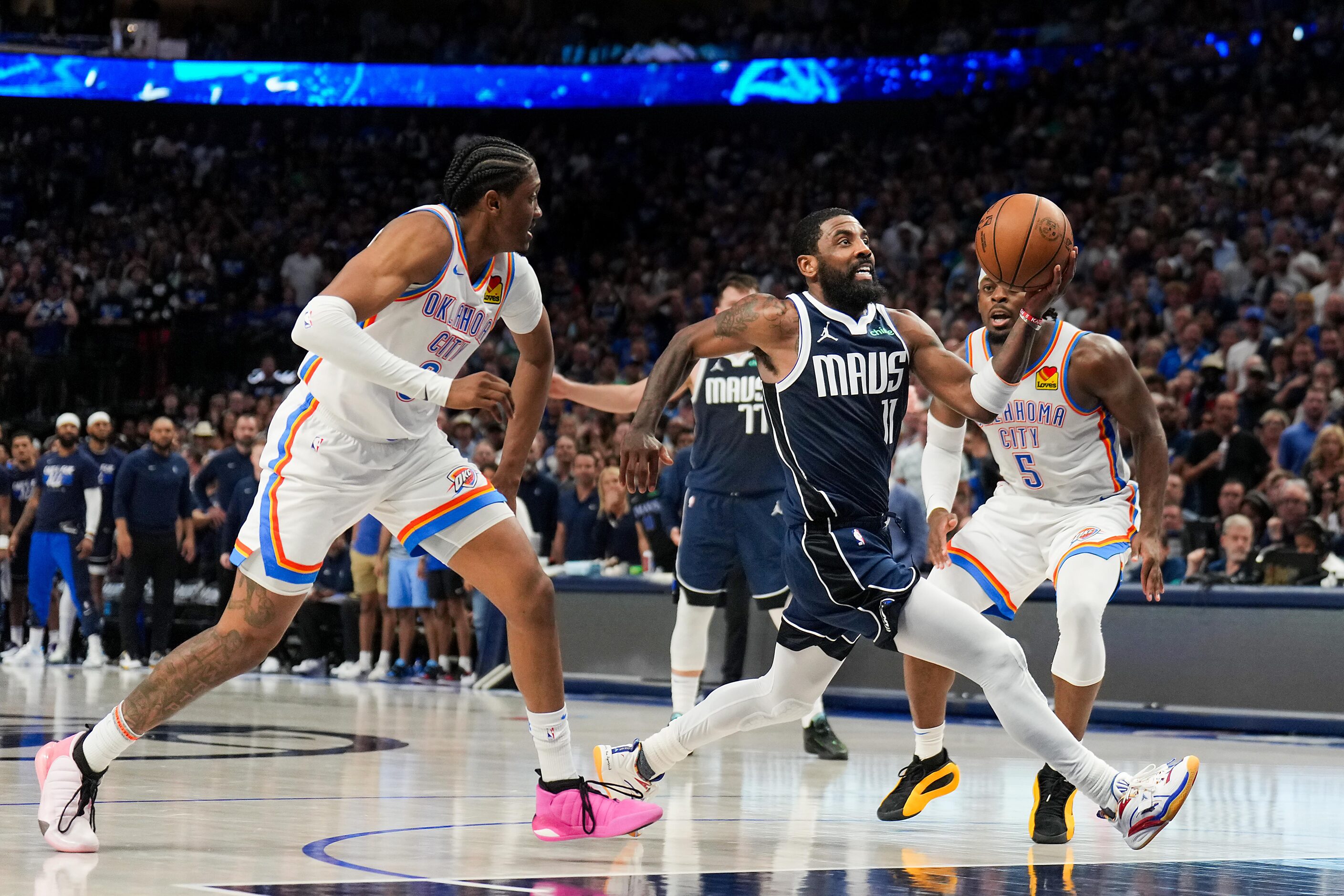 Dallas Mavericks guard Kyrie Irving (11) drives to the basket past Oklahoma City Thunder...