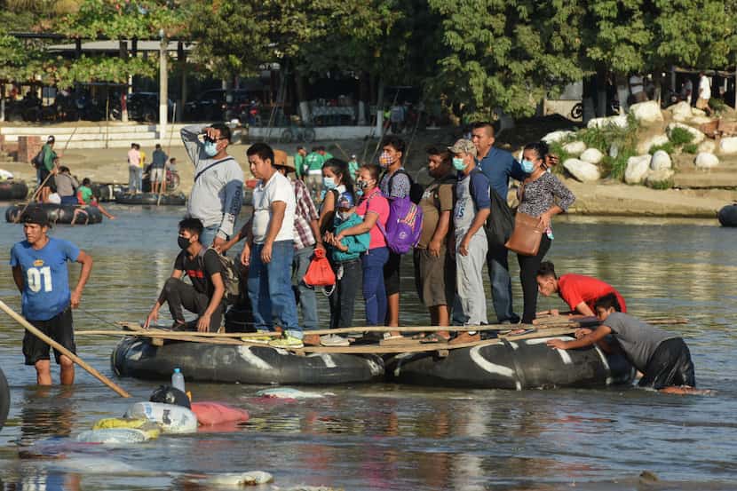 Personas en una balsa cruzan el Río Suchiate que separa Guatemala y Ciudad Hidalgo, Chiapas,...