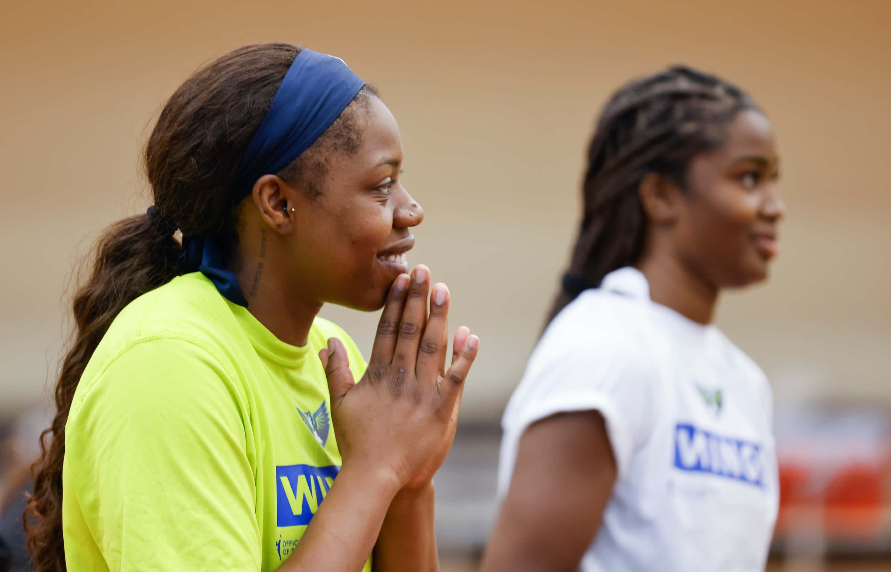 Dallas Wings guard Arike Ogunbowale smiles as she listens to her teammates during a training...