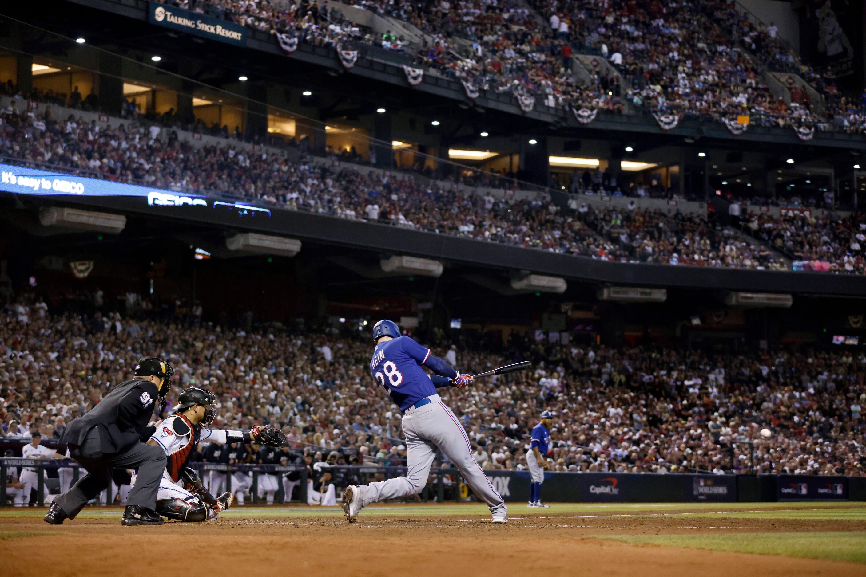 Texas Rangers catcher Jonah Heim (28) connects on a two-run single during the ninth inning...