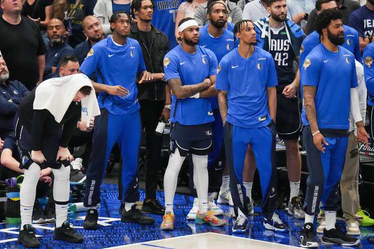 Dallas Mavericks guard Luka Doncic (left) watches from the bench in the final minute of a...