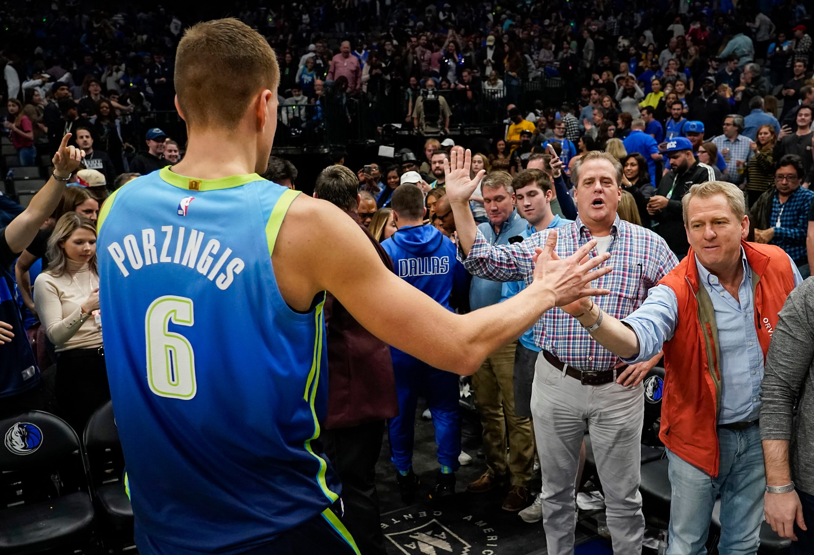 Dallas Mavericks forward Kristaps Porzingis high fives fans as he leaves the court after a...