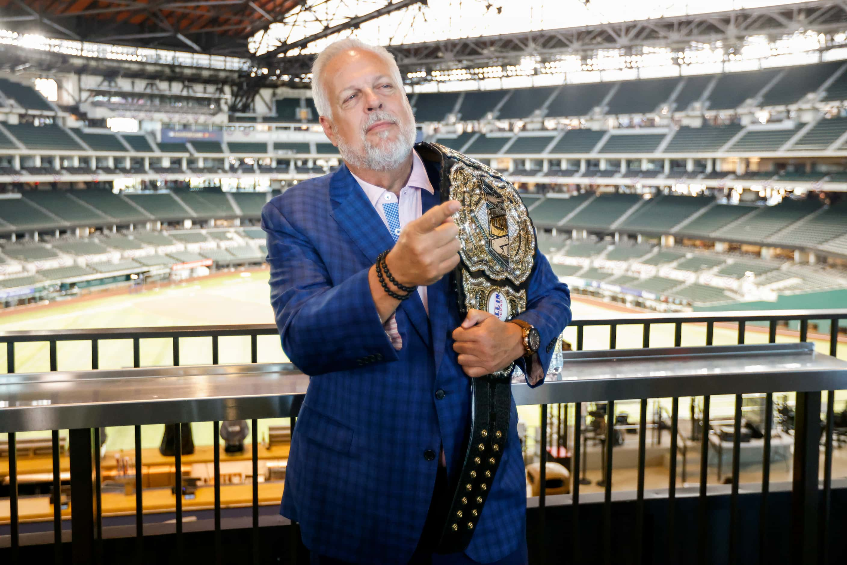 Arlington mayor Jim Ross poses with an AEW championship belt after the announcement of a...