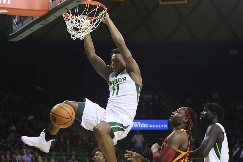 Baylor forward Mark Vital, left, scores past Iowa State forward Solomon Young, right, during...