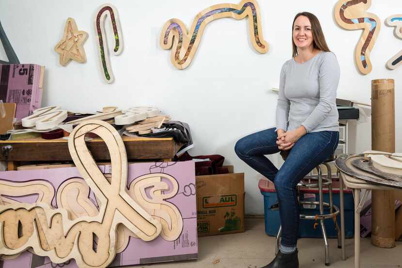 Artist Kaylee Appleton sits in her studio, surrounded by her work.