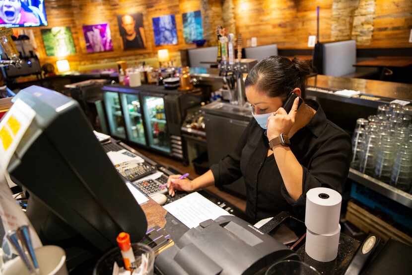 Server Lenny Adams takes a phone order during a business lull at Maguire's, an upscale...