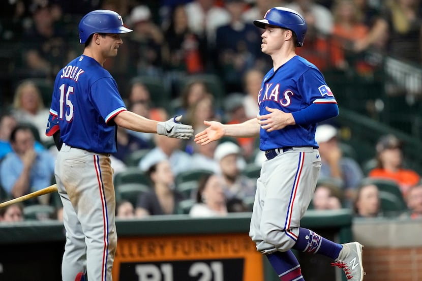 Texas Rangers' Brock Holt, right, celebrates with Nick Solak (15) after scoring during the...