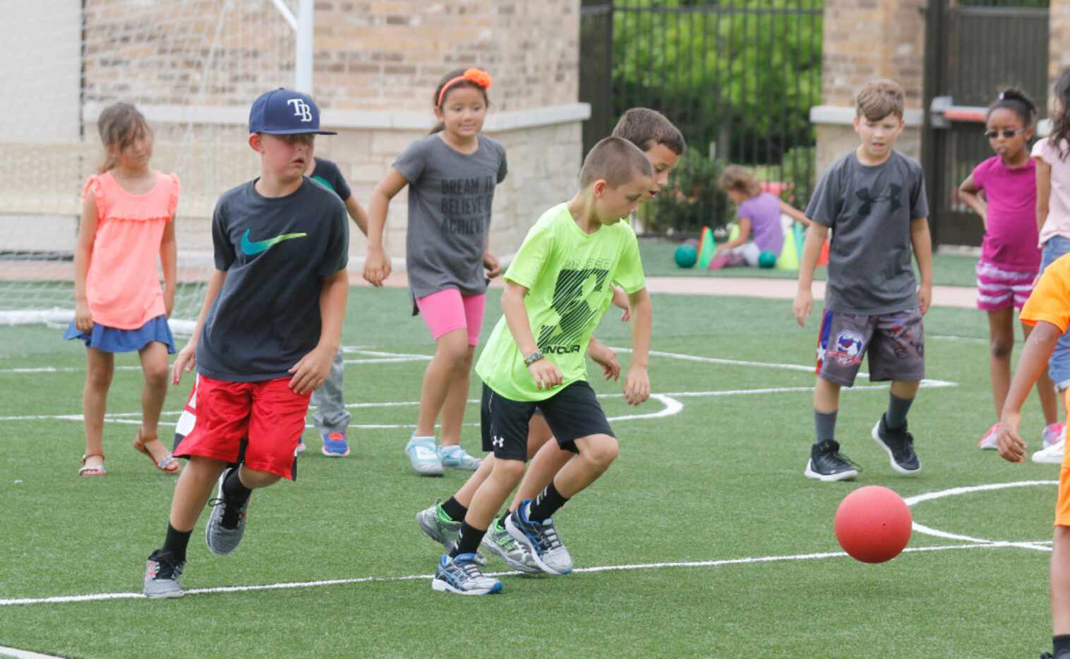 Children play soccer on the Children's Learning Adventure  playground in McKinney. The...