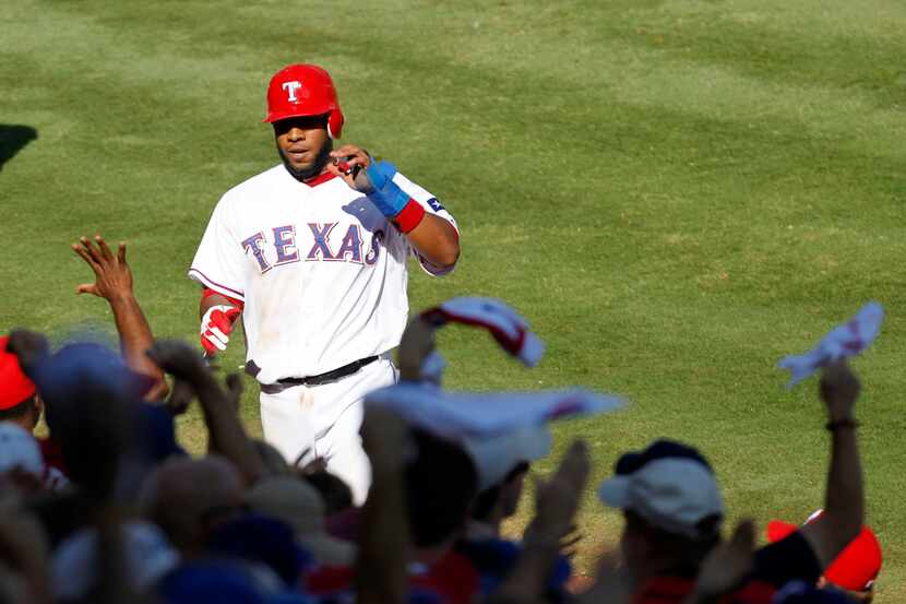 Texas Rangers shortstop Elvis Andrus walks into the dugout after scoring on a double by Josh...