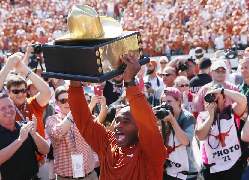 Texas Longhorns head coach Charlie Strong celebrates with the Golden Hat after his team...