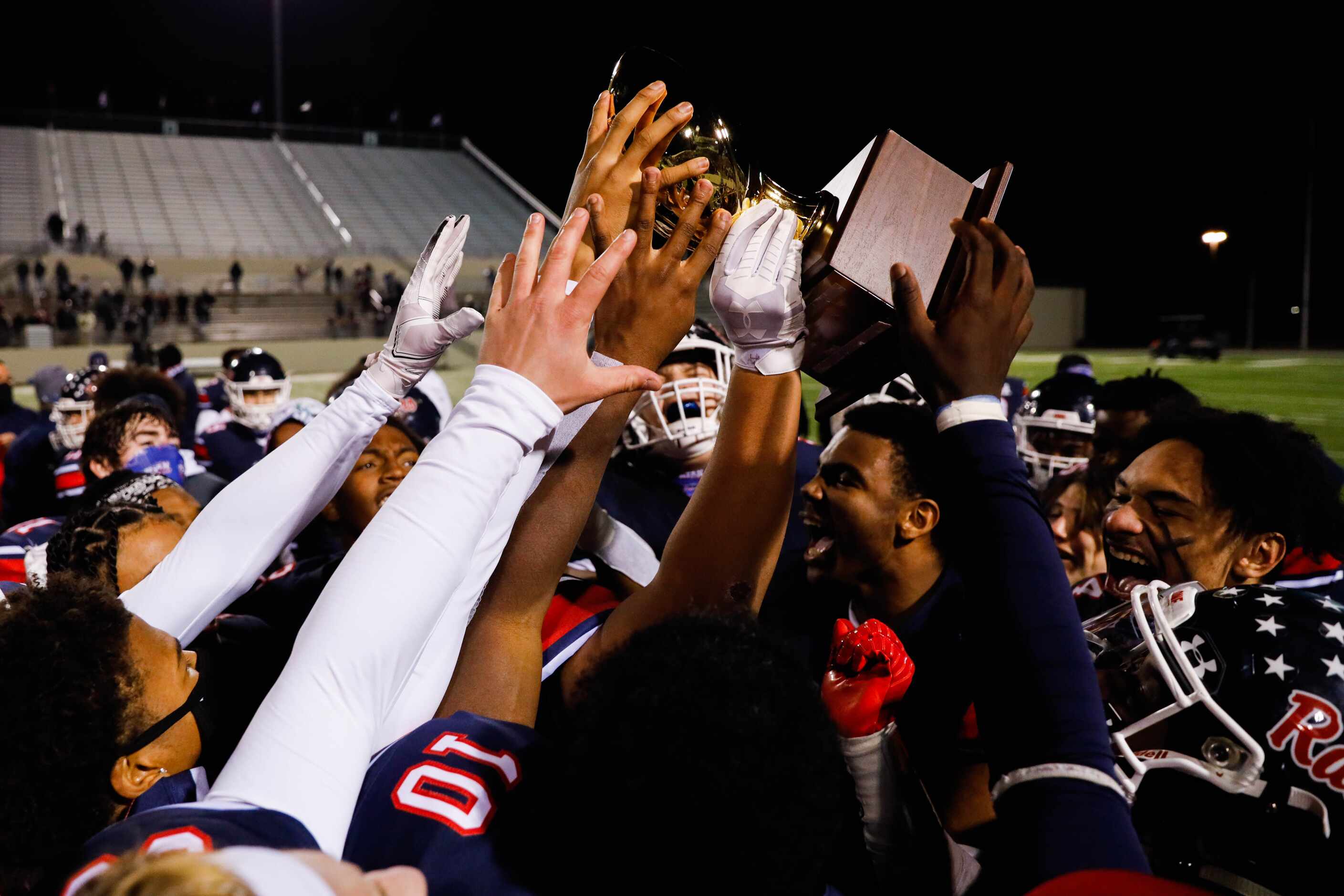 Denton Ryan football players celebrate winning the District 5-5A Division I title against...
