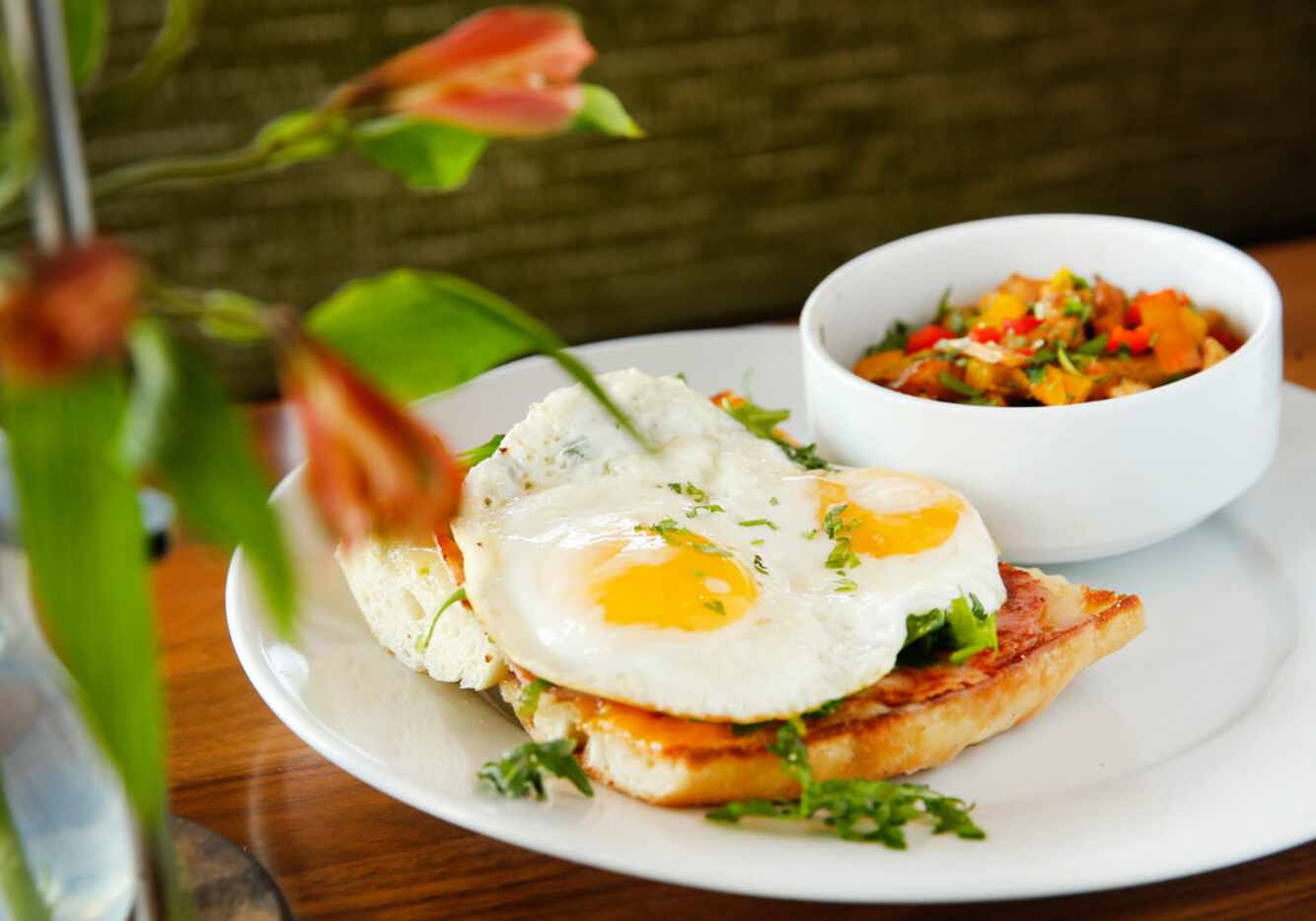 The open-faced sandwich is a local baguette with two fried eggs all-natural ham swiss and...