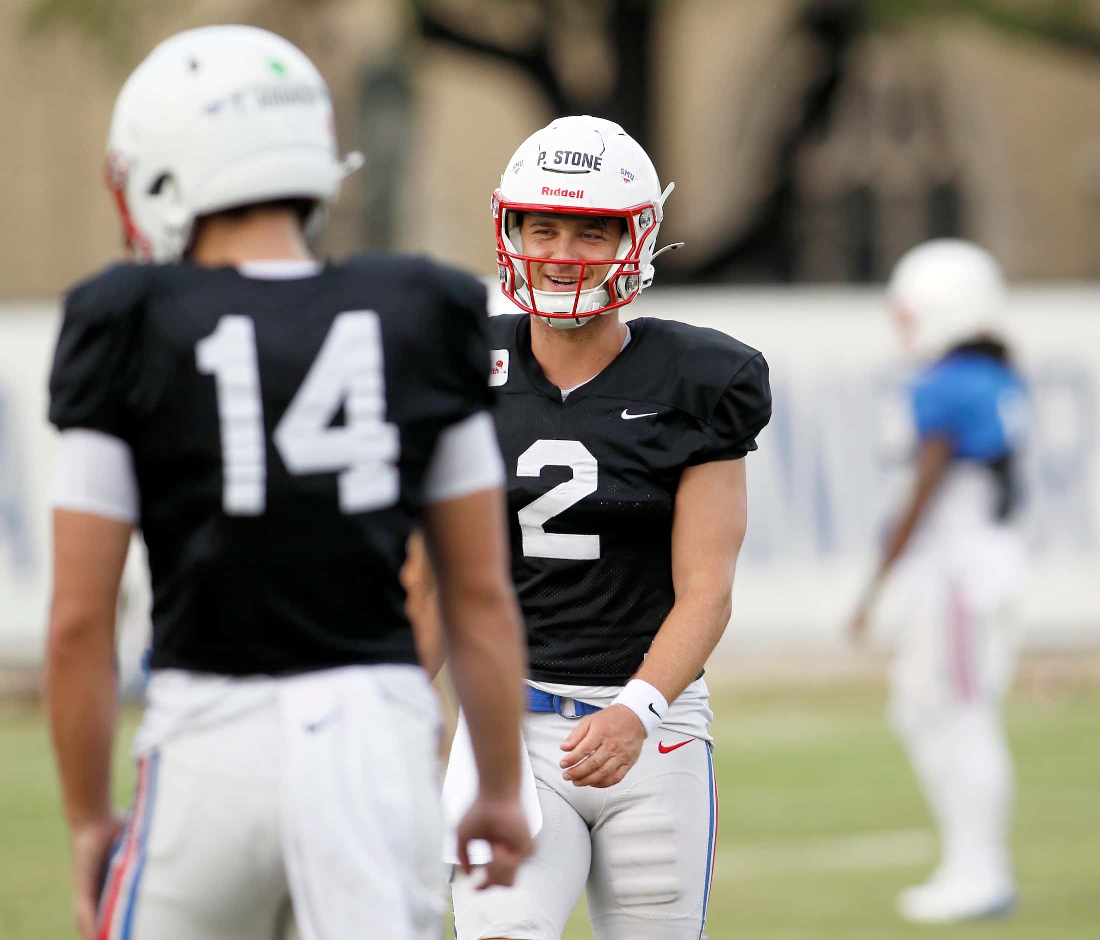 SMU Mustangs starting quarterback Preston Stone (2) shares a light moment with teammates...