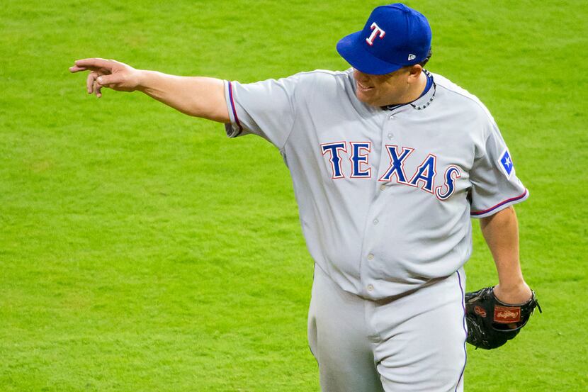 Texas Rangers starting pitcher Bartolo Colon leaves the game after carrying a perfect game...