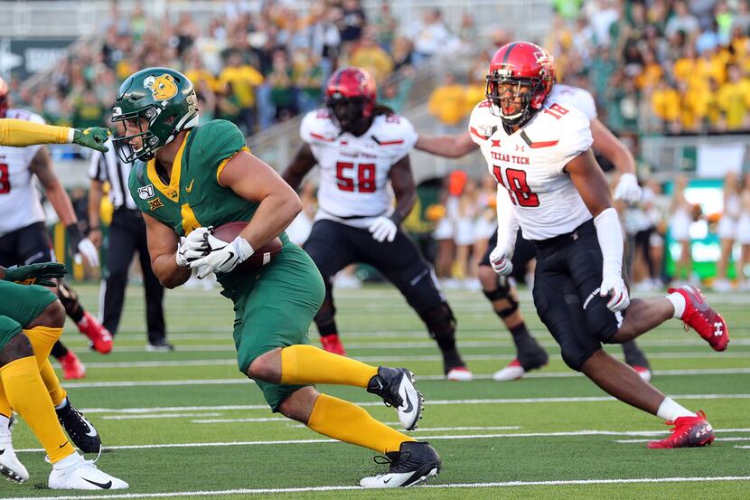 WACO, TEXAS - OCTOBER 12: Clay Johnston #4 of the Baylor Bears is chased by Cameron Cantrell...