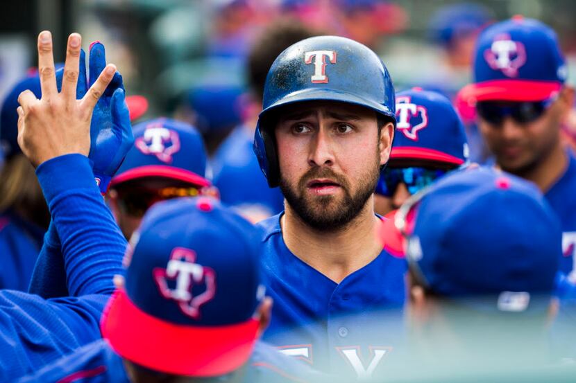 Texas Rangers designated hitter Joey Gallo (13) gets high fives in the dugout after scoring...