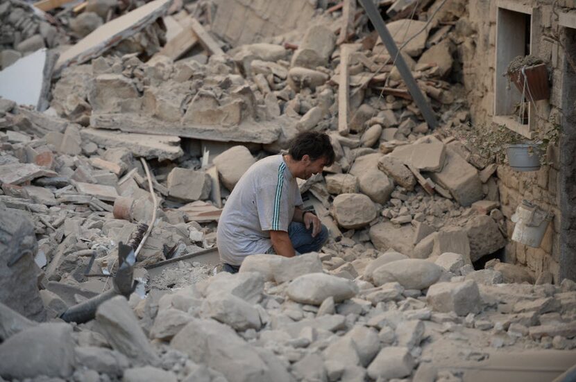 A man reacts to his damaged home after a strong heartquake hit Amatrice on August 24, 2016. 