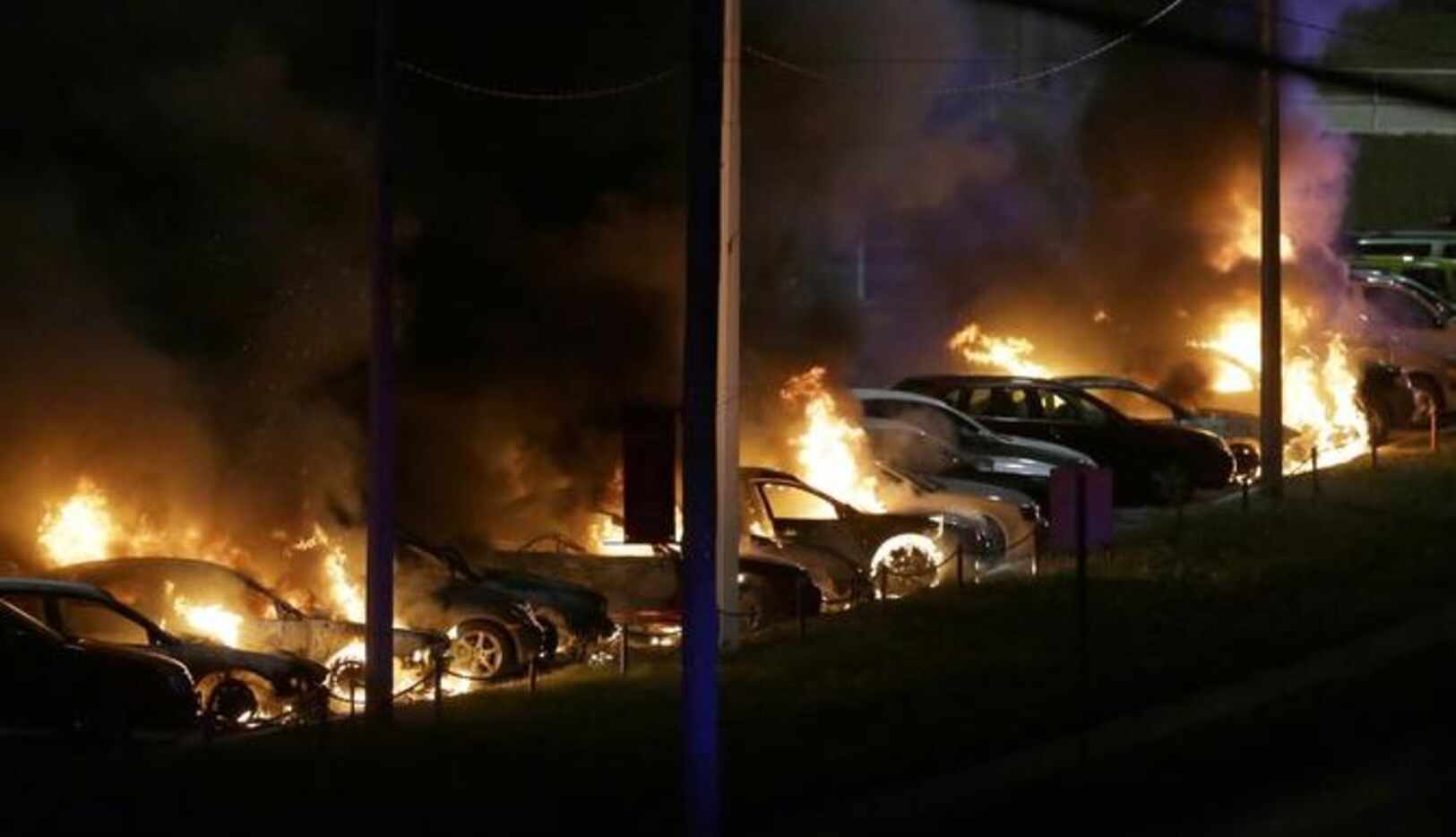 Autos arden en llamas en una agencia de vehículos en Ferguson, Missouri, la noche del lunes,...