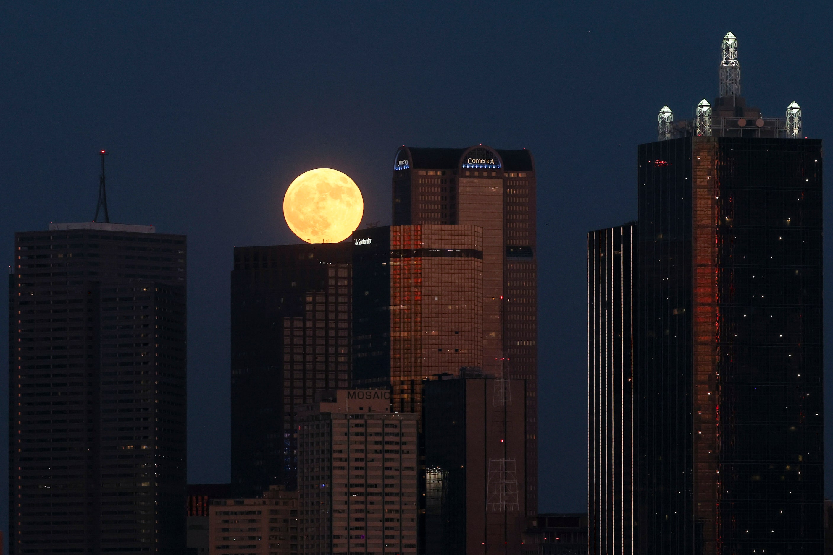 A full super harvest moon rises behind the Dallas skyline, on Tuesday, Sept. 17, 2024. 