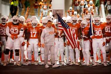 Texas Longhorns head coach Steve Sarkisian (center) leads his players down the tunnel before...